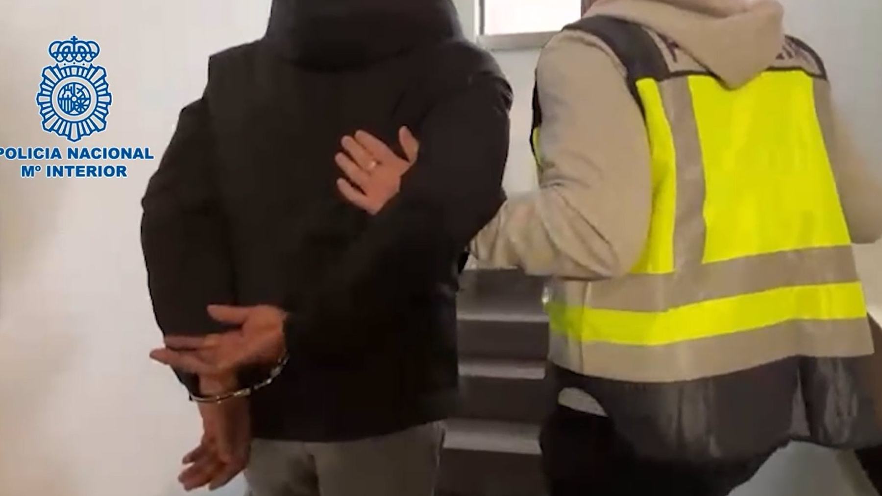 Uno de los detenidos, en dependencias policiales de Palma, junto a un agente. POLICÍA NACIONAL