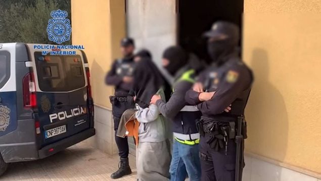 Varios agentes junto a un yihadista detenido.