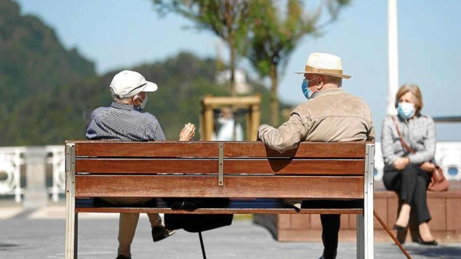 Dos jubilados conversan en un banco frente al mar. Efe