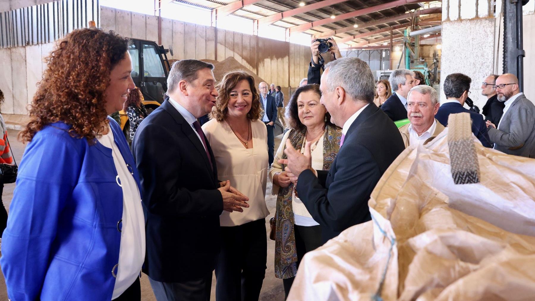 El ministro de Agricultura, Luis Planas, escucha las explicaciones del presidente de la Cooperativa Camp Mallorquí, Miquel Gual, durante una visita a las instalaciones, junto a la presidenta del Govern, Francina Armengol, entre otras autoridades.