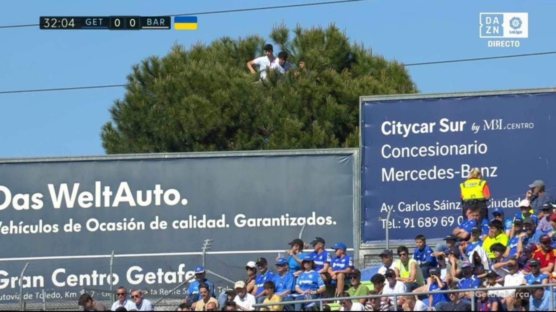 Tres aficionados presenciando el Getafe-Barcelona desde un árbol. (Captura de pantalla)