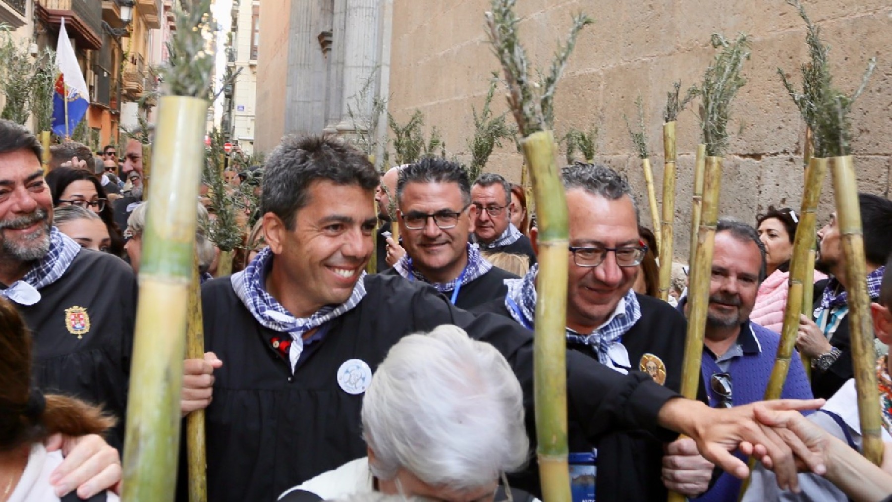 Mazón, que todos los años participa en la Peregrina, estrecha la mano de un alicantino, este jueves en Alicante.