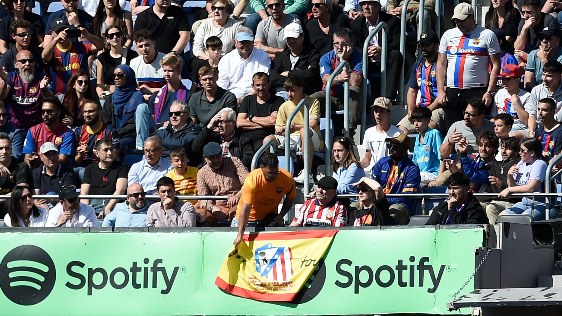 Un operario retira la bandera de España con el escudo del Atlético. (AFP)