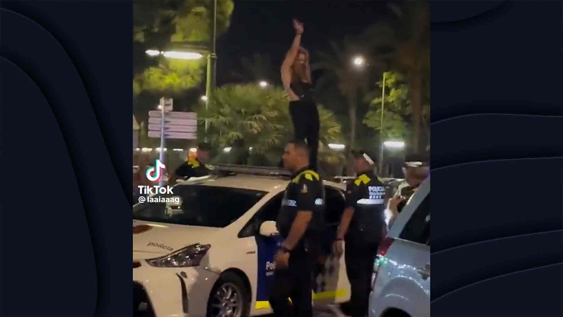 Mujer baila encima de un coche de policía