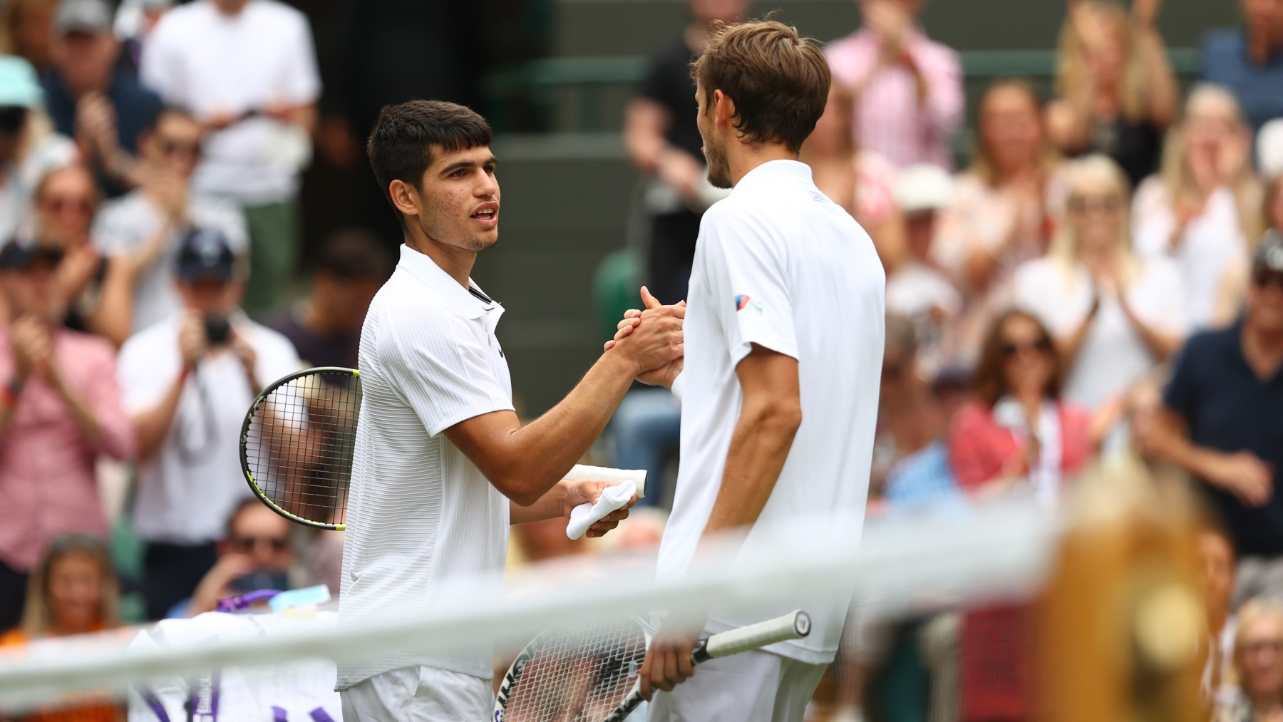 Alcaraz y Medvedev se saludan en la red tras su partido en Wimbledon 2021. (Getty)