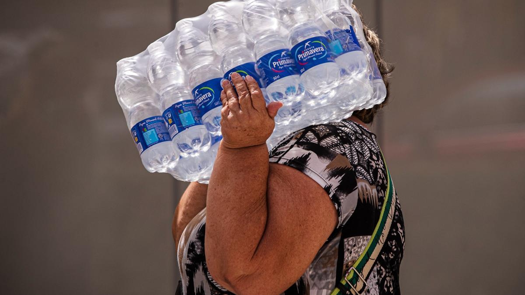 Una mujer con botellas de agua este miércoles en la playa de la Malagueta (EFE).