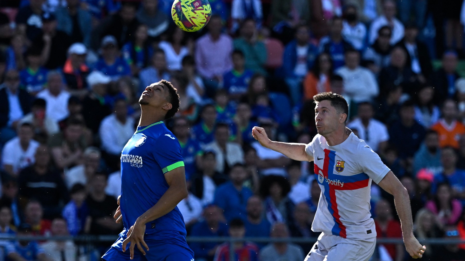 Gastón Álvarez y Lewandowski pelean por un balón en el Getafe-Barcelona. (AFP)