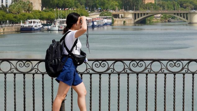 Una persona camina por el Puente de Triana, en Sevilla.