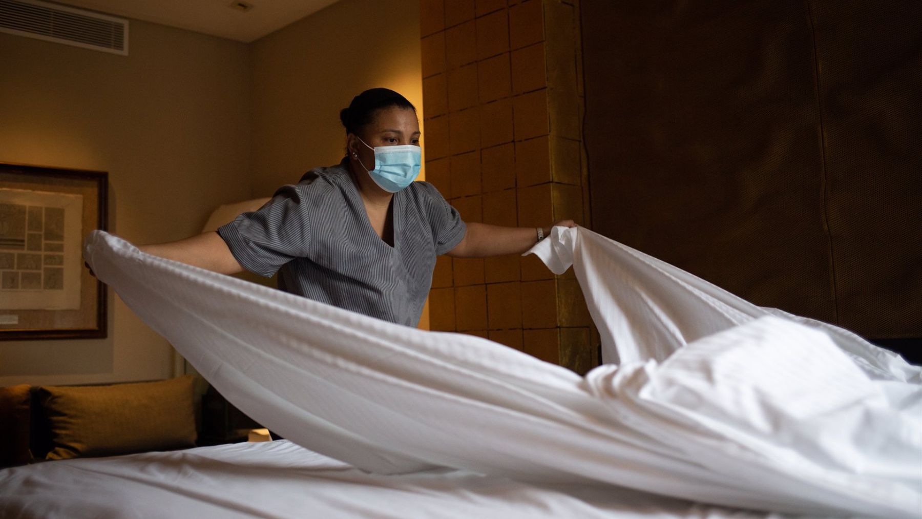 Una trabajadora cambia las sábanas de una cama de un hotel