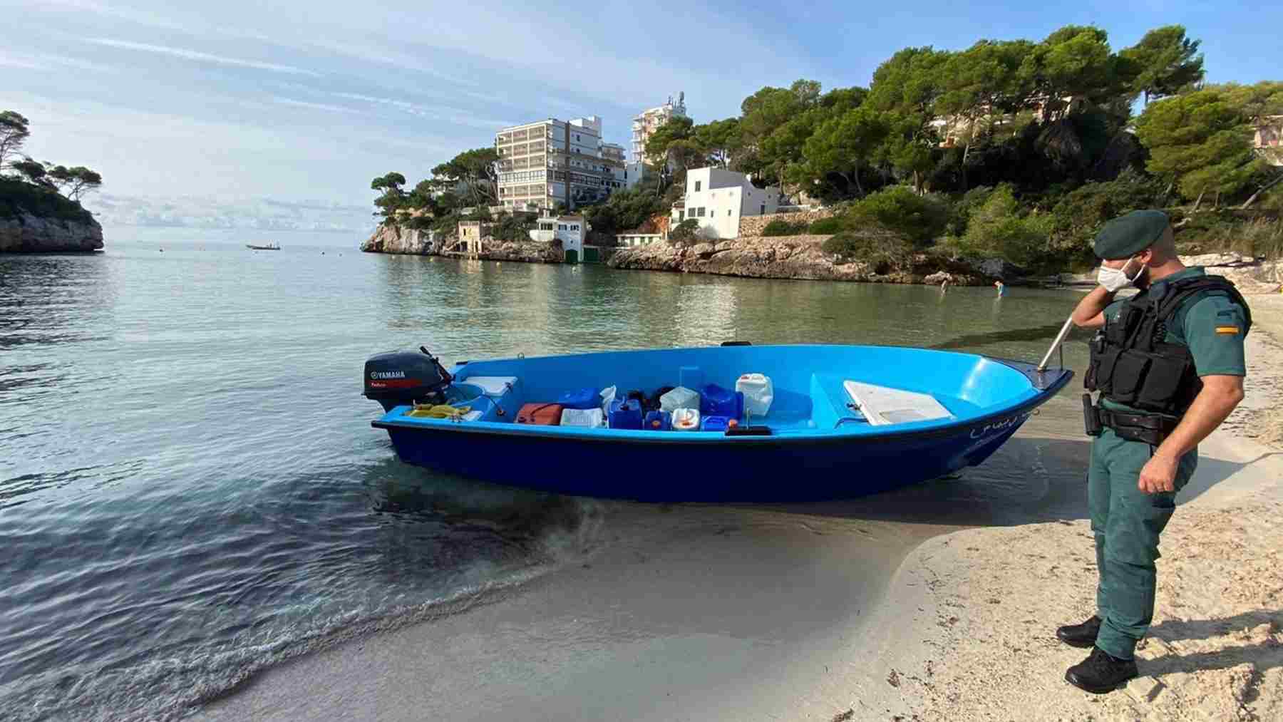 Un agente de la guardia civil, junto a una embaración, en una playa de Baleares. GUARDIA CIVIL