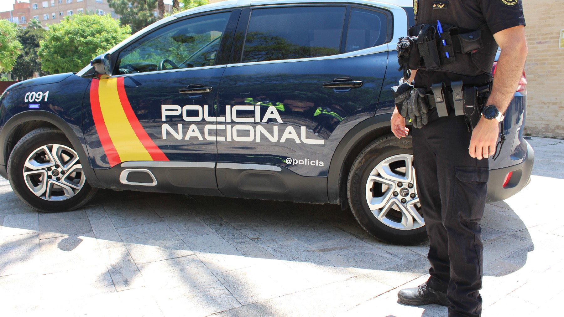Un agente junto a un vehículo de la Policía Nacional.