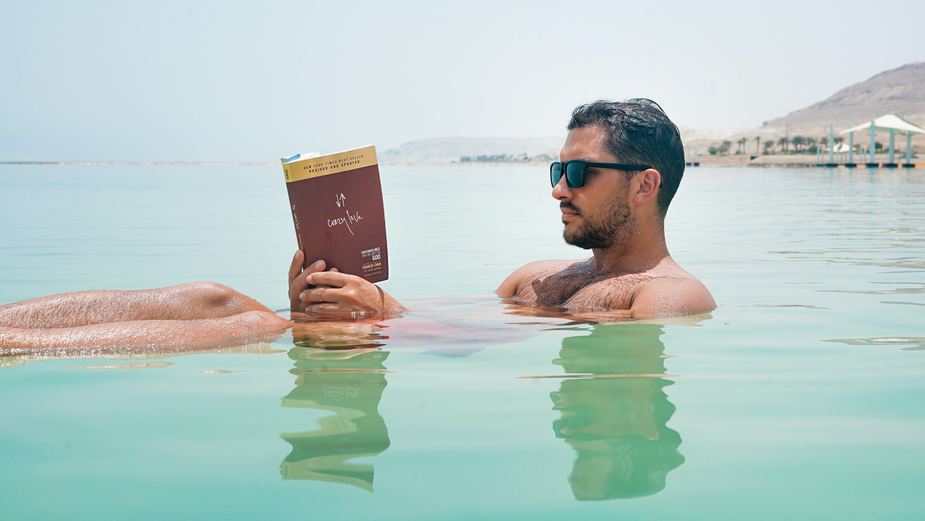 Un hombre, leyendo un libro en el mar. (Pexels_Toa Heftiba)