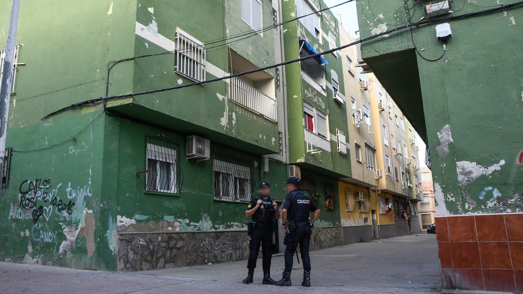 Cordón policial frente a la vivienda de la mujer asesinada en el barrio de Pescadería, en Almería (EFE).