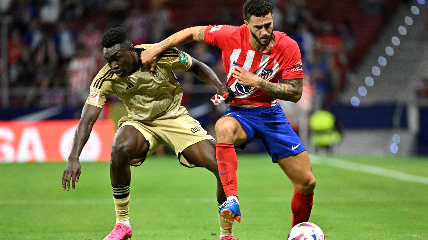 Samu Omorodion disputa un balón con Hermoso.