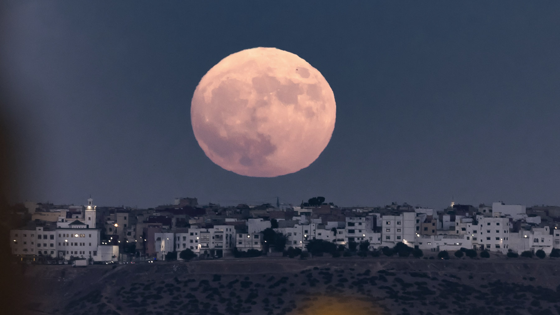 La superluna de agosto se ve inmensa sobre la ciudad de Rabat, en Marruecos (Foto: AFP).