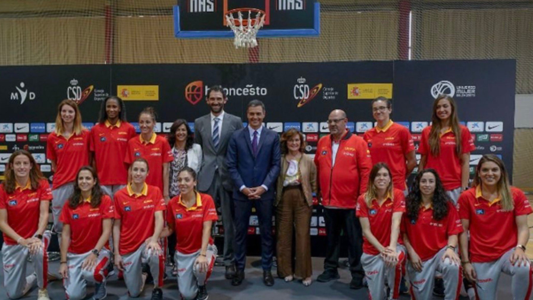 Pedro Sánchez, en el centro, de pie, con la selección de baloncesto femenino. Delante, siete de las deportistas rodilla en tierra.