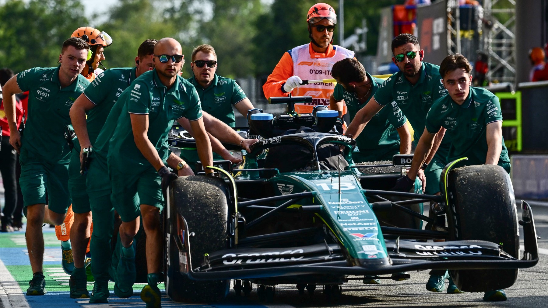 Los mecánicos de Aston Martin llevan el monoplaza de Lance Stroll en el último Gran Premio. (AFP)