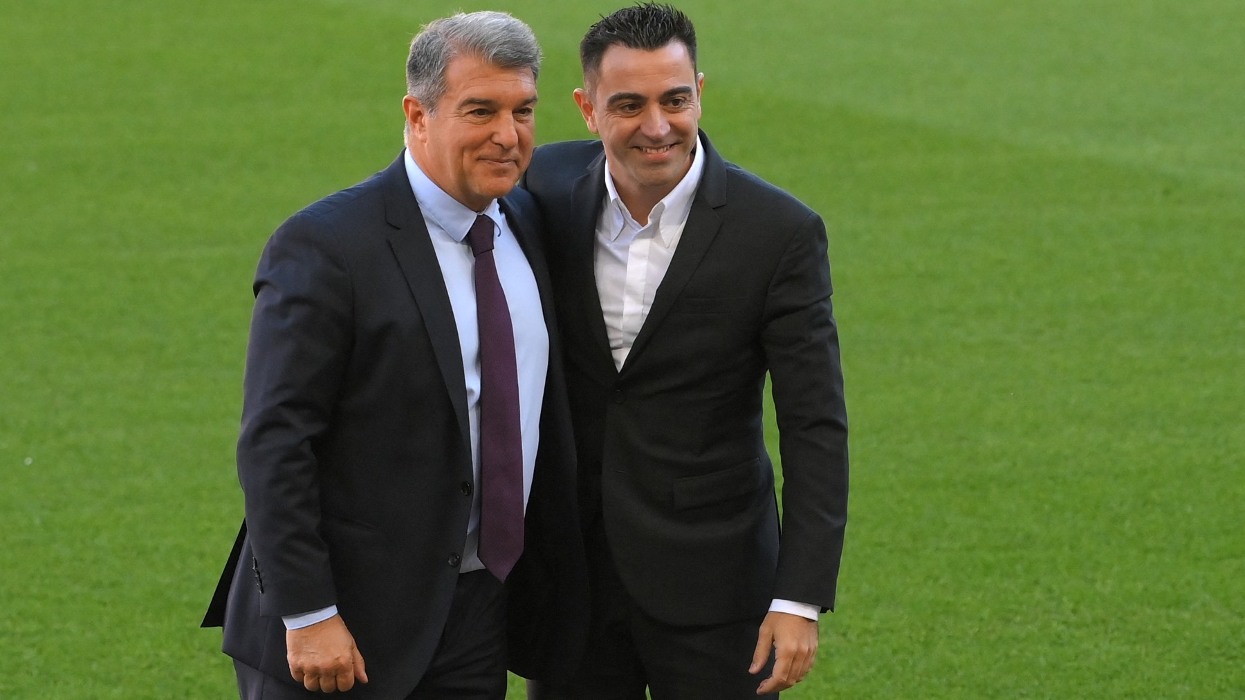 Xavi Hernández junto a Joan Laporta. (AFP)