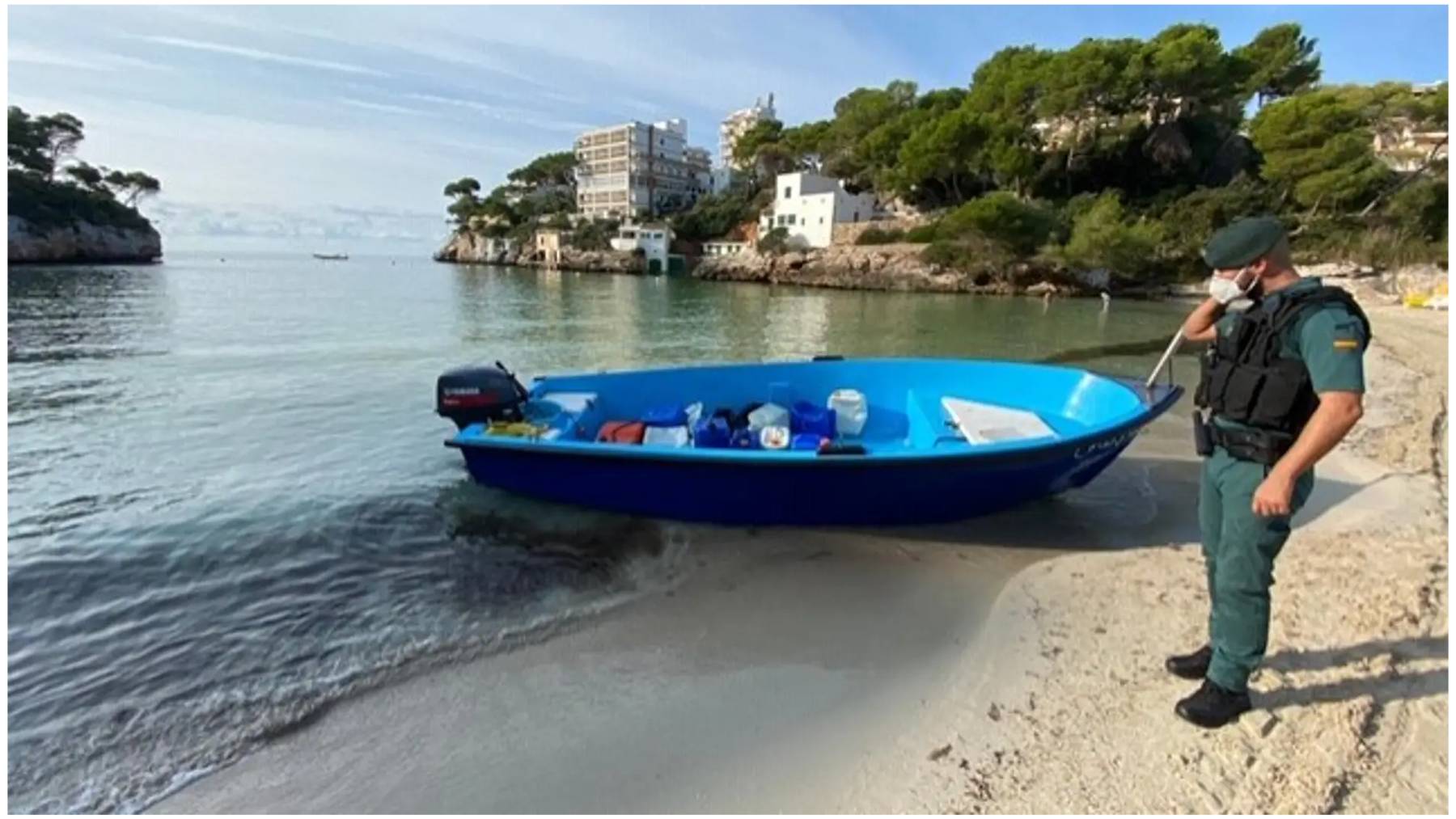 Un agente de la Guardia Civil junto a una patera.