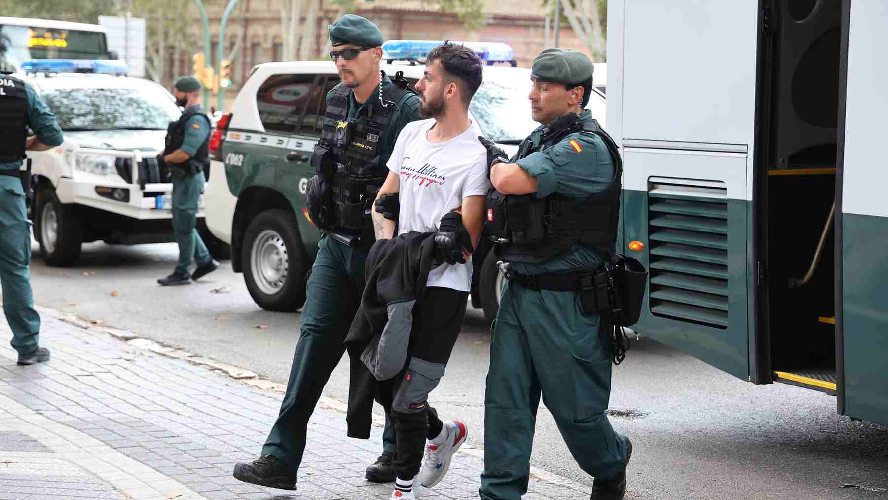 Dos agentes de la Guardia Civil escoltan a uno de los detenidos.  Isaac Buj – Europa Press