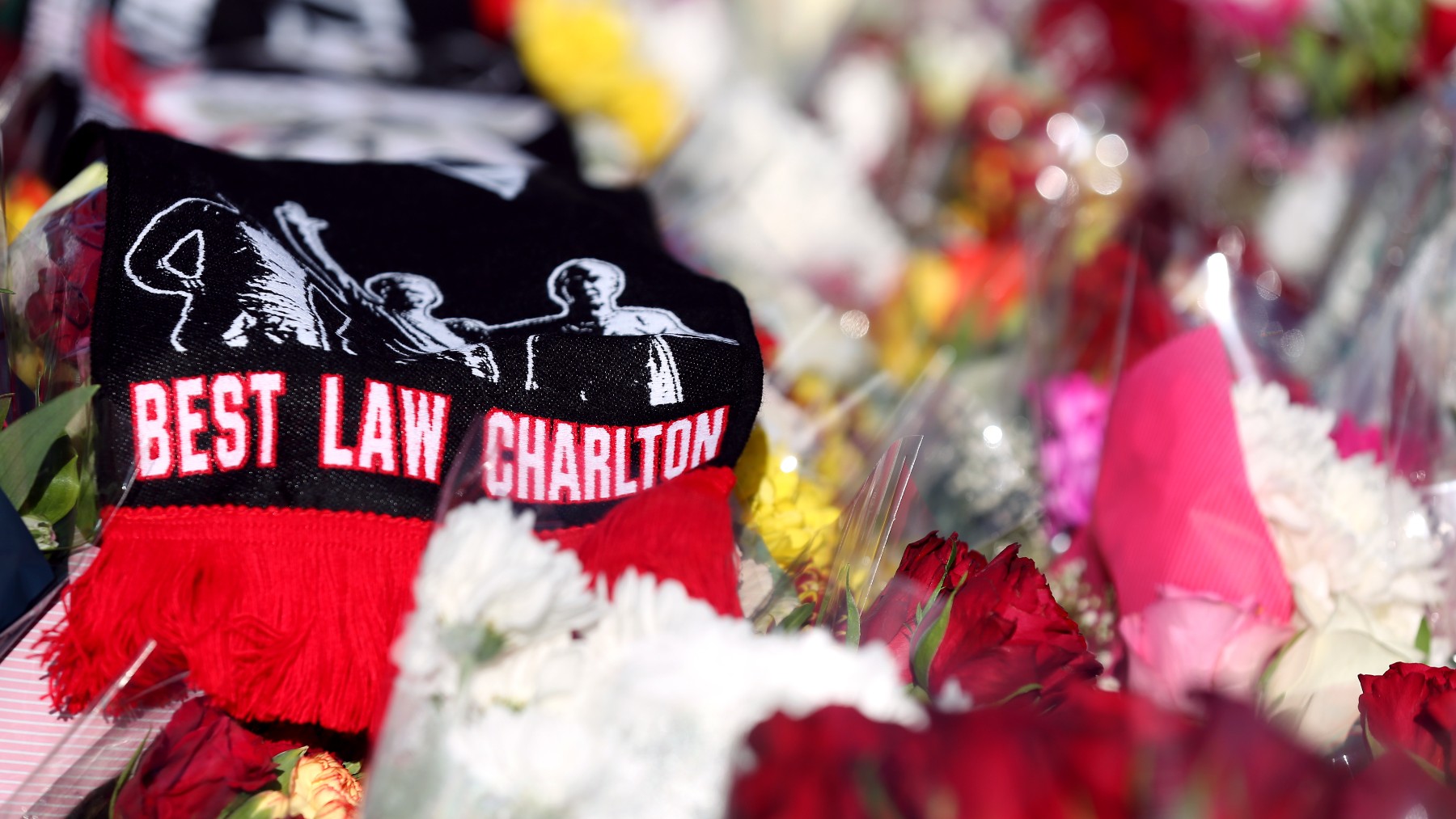 Flores y bufandas depositadas en la estatua de Bobby Charlton, en Old Trafford. (Europa Press)
