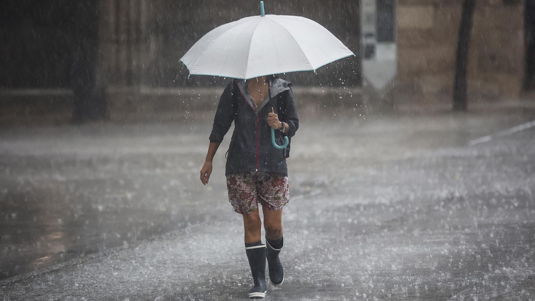 Una persona camina con un paraguas bajo la lluvia.