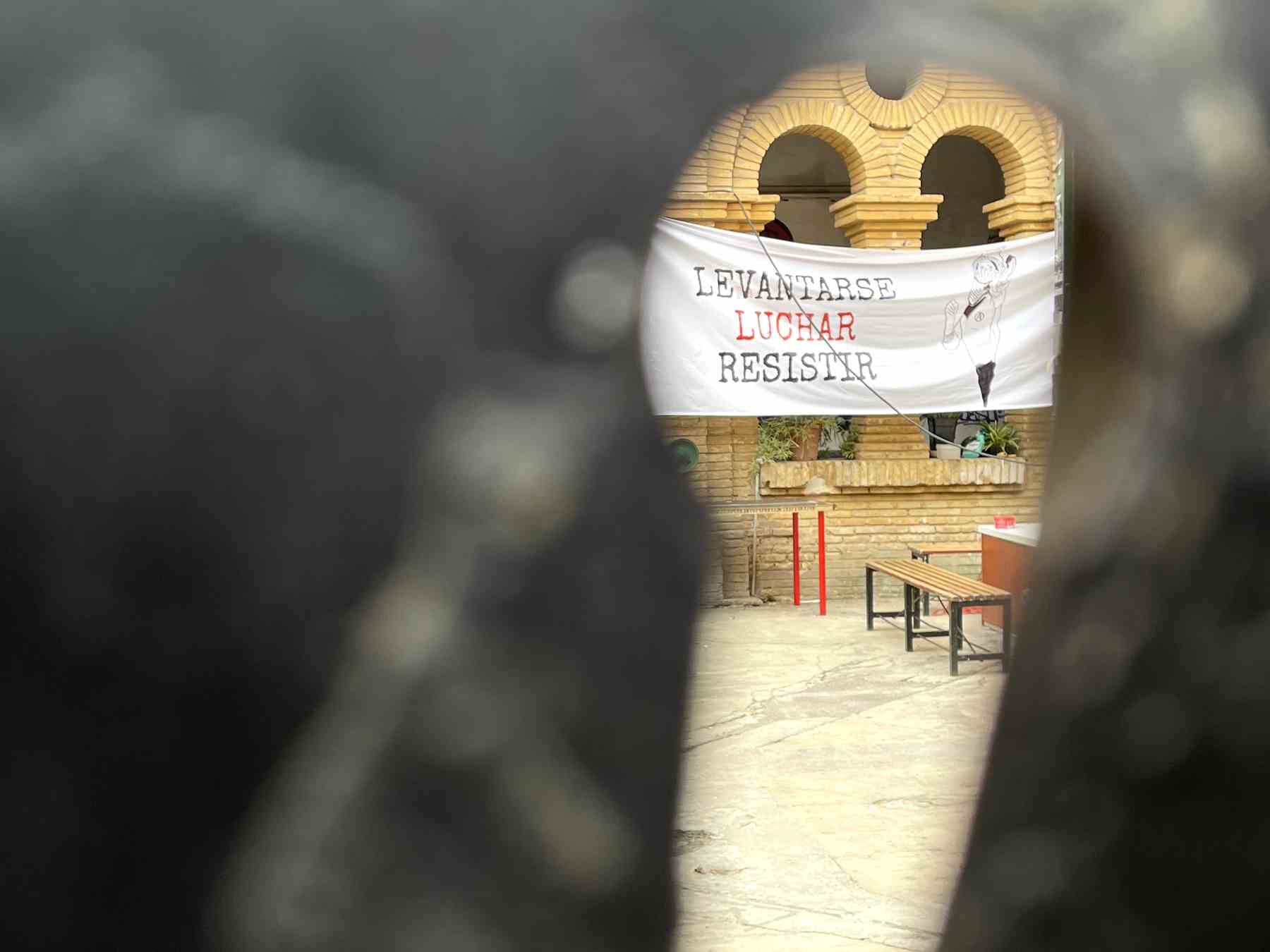 Imagen desde la mirilla del edificio ocupado por el CSO Kike Mur, donde se vislumbra la pancarta que alienta la violencia.