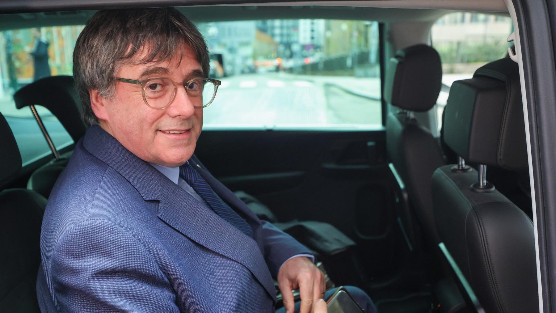 Puigdemont, en el coche, tras presentar el acuerdo con el PSOE en Bruselas.