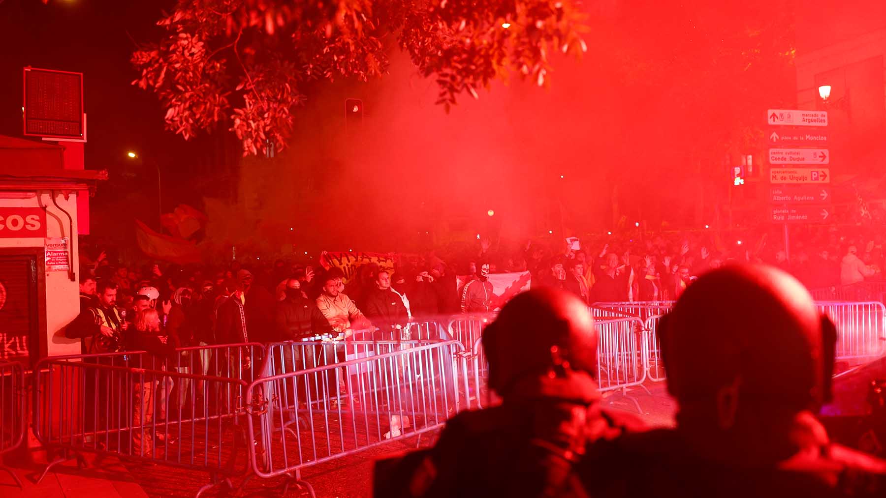 Agentes antidisturbios de la Policía Nacional, este domingo, ante manifestantes congregados en los alrededores de la sede central del PSOE, en Madrid.