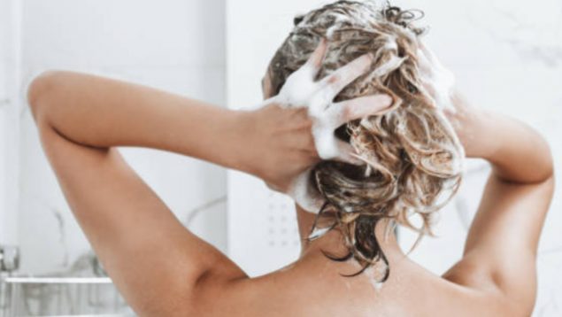 Mujer lavándose el pelo.