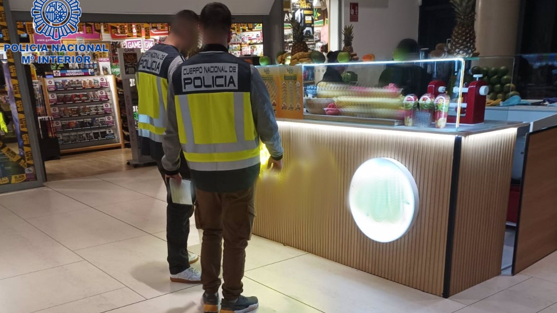 Agentes de la Policía Nacional inspeccionando una de las tiendas.