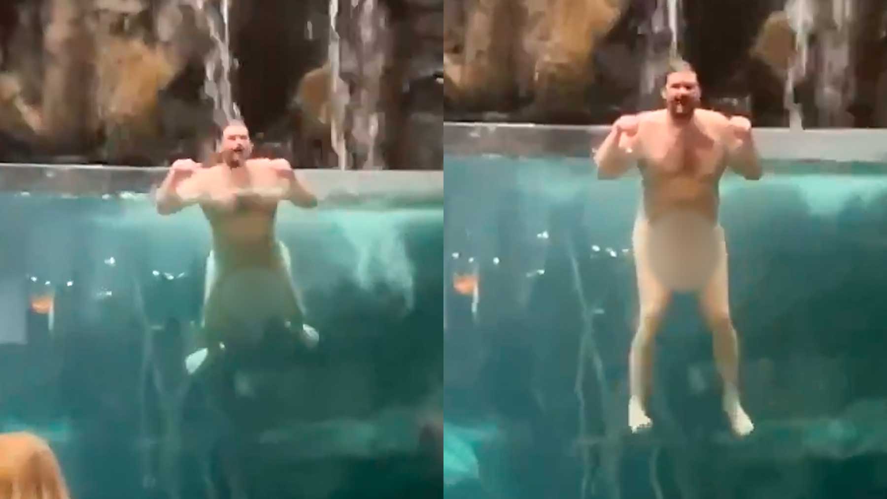 Hombre nadando desnudo en el acuario.