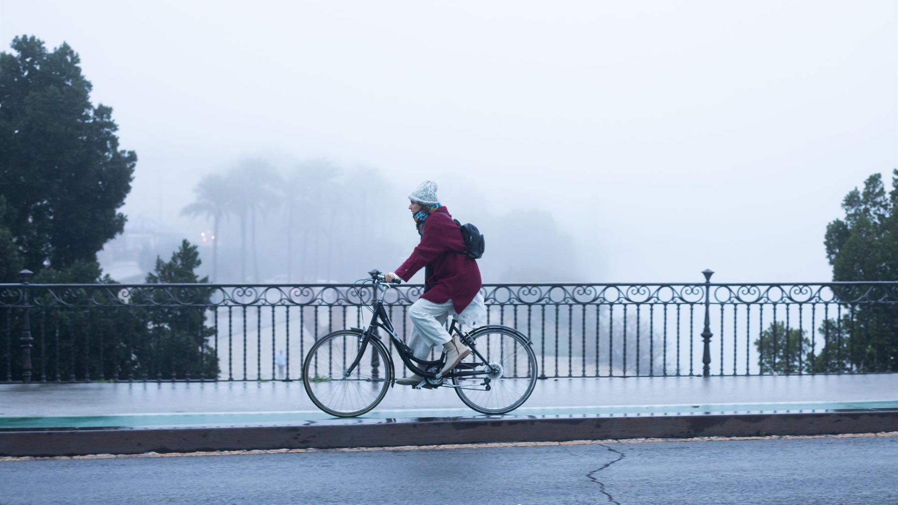 Imagen de una ciclista se protege del frío con gorro y guantes.