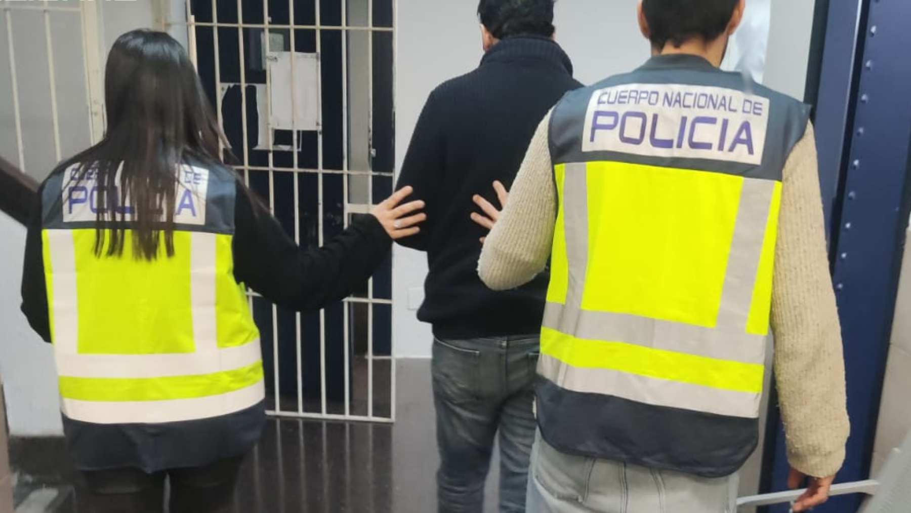 El detenido, siendo escoltado por dos agentes de la Policía Nacional.