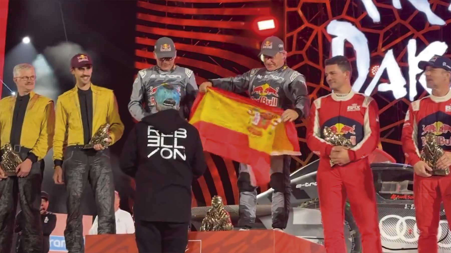 Carlos Sainz luce la bandera de España al término del Dakar.