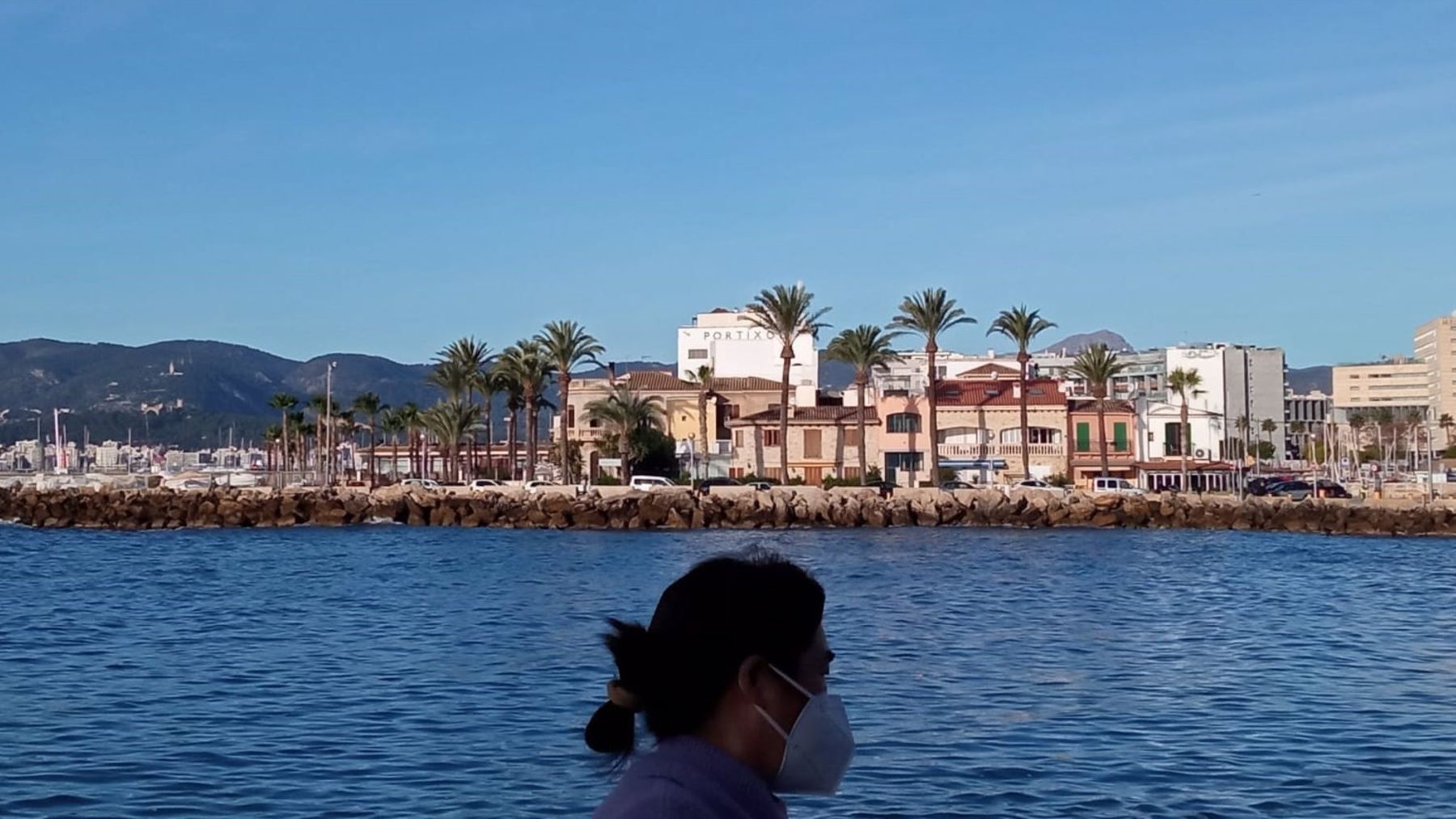 Una mujer pasea con mascarilla en un día soleado, en Palma. (EP