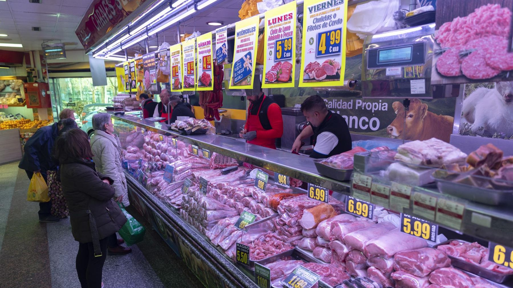 Varias personas compran en una carnicería en un mercado. (Europa Press)