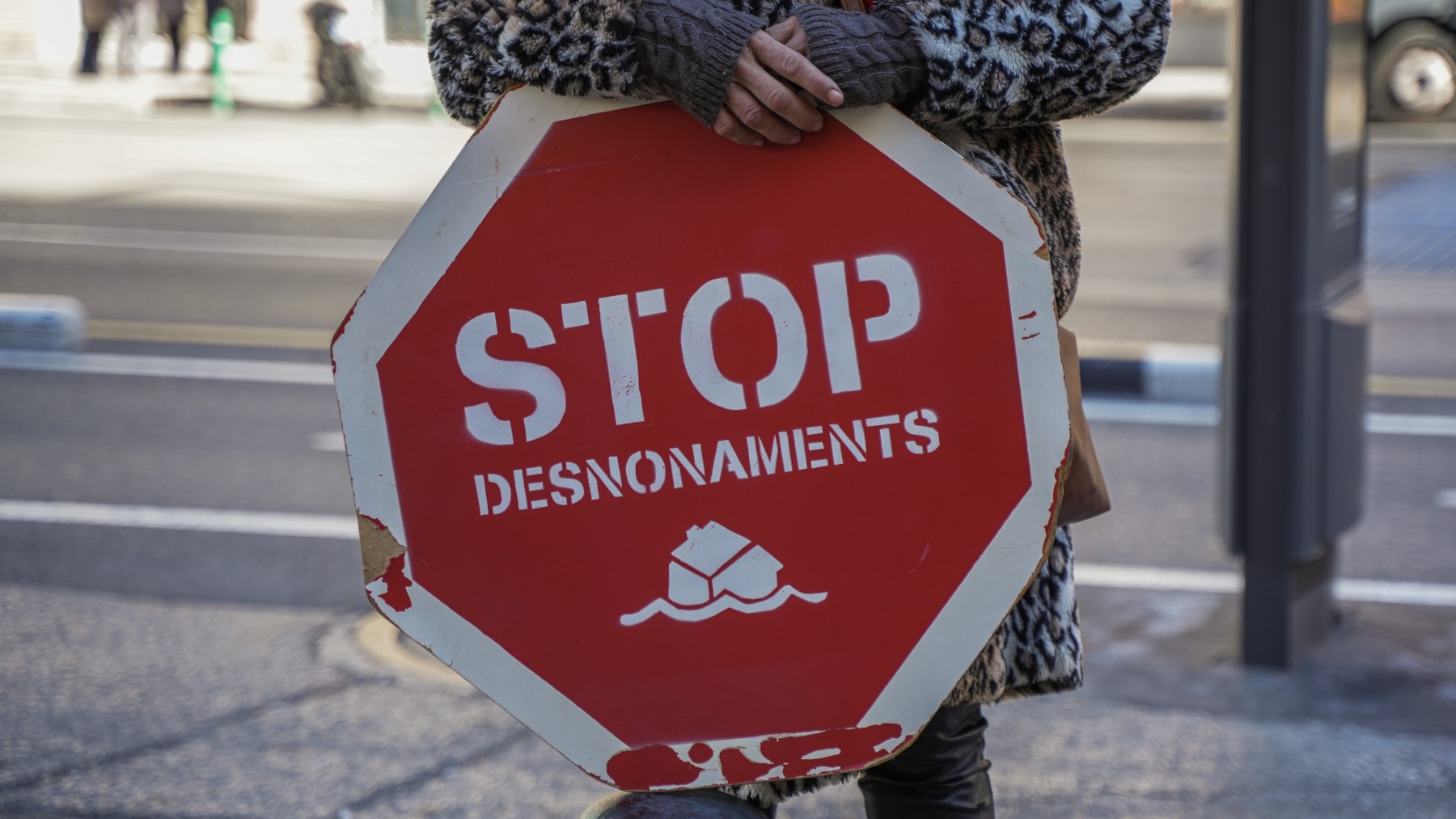 Una persona sujeta un cartel de ‘Stop desnonamients’ durante una concentración de la PAH.