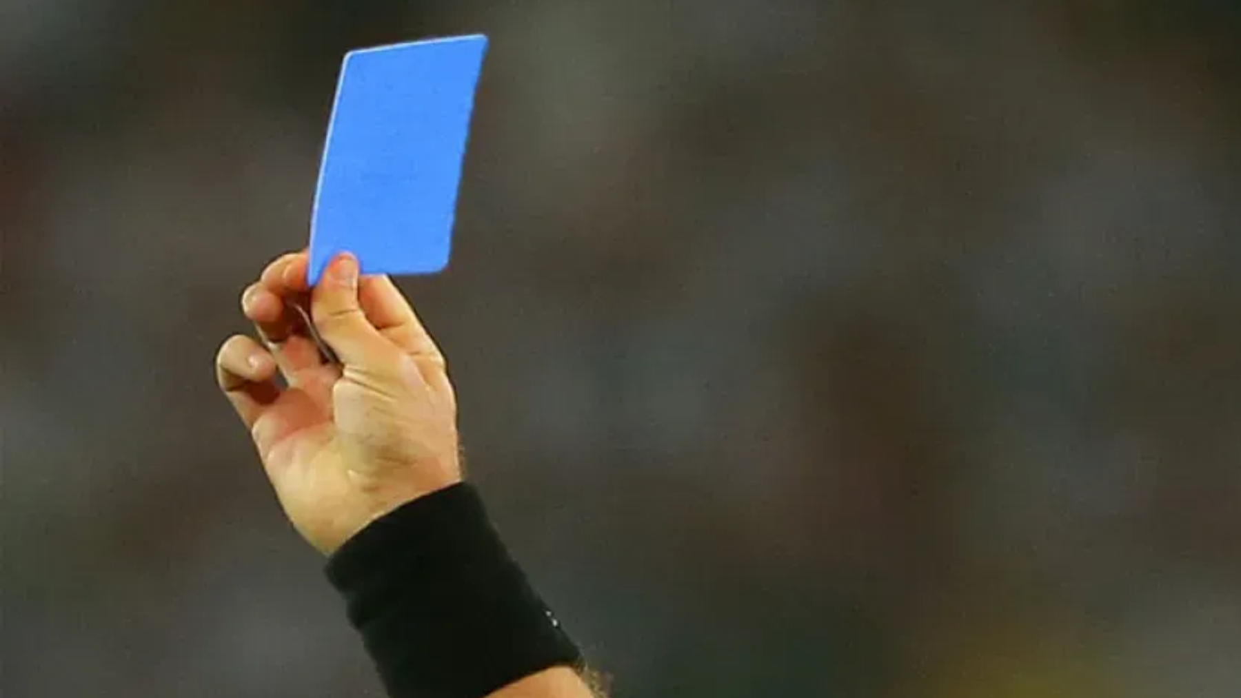 Un árbitro muestra la tarjeta azul.