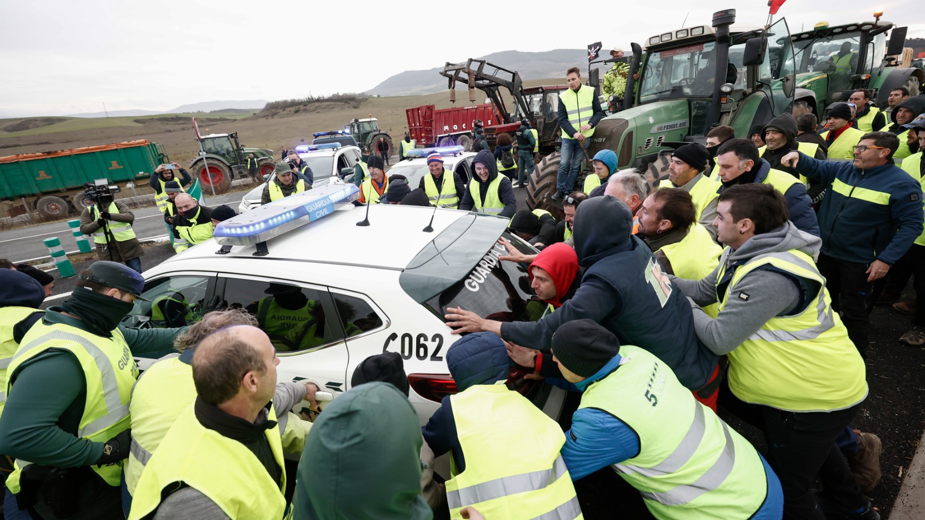 Un grupo de agricultores zarandea un coche de la Guardia Civil.