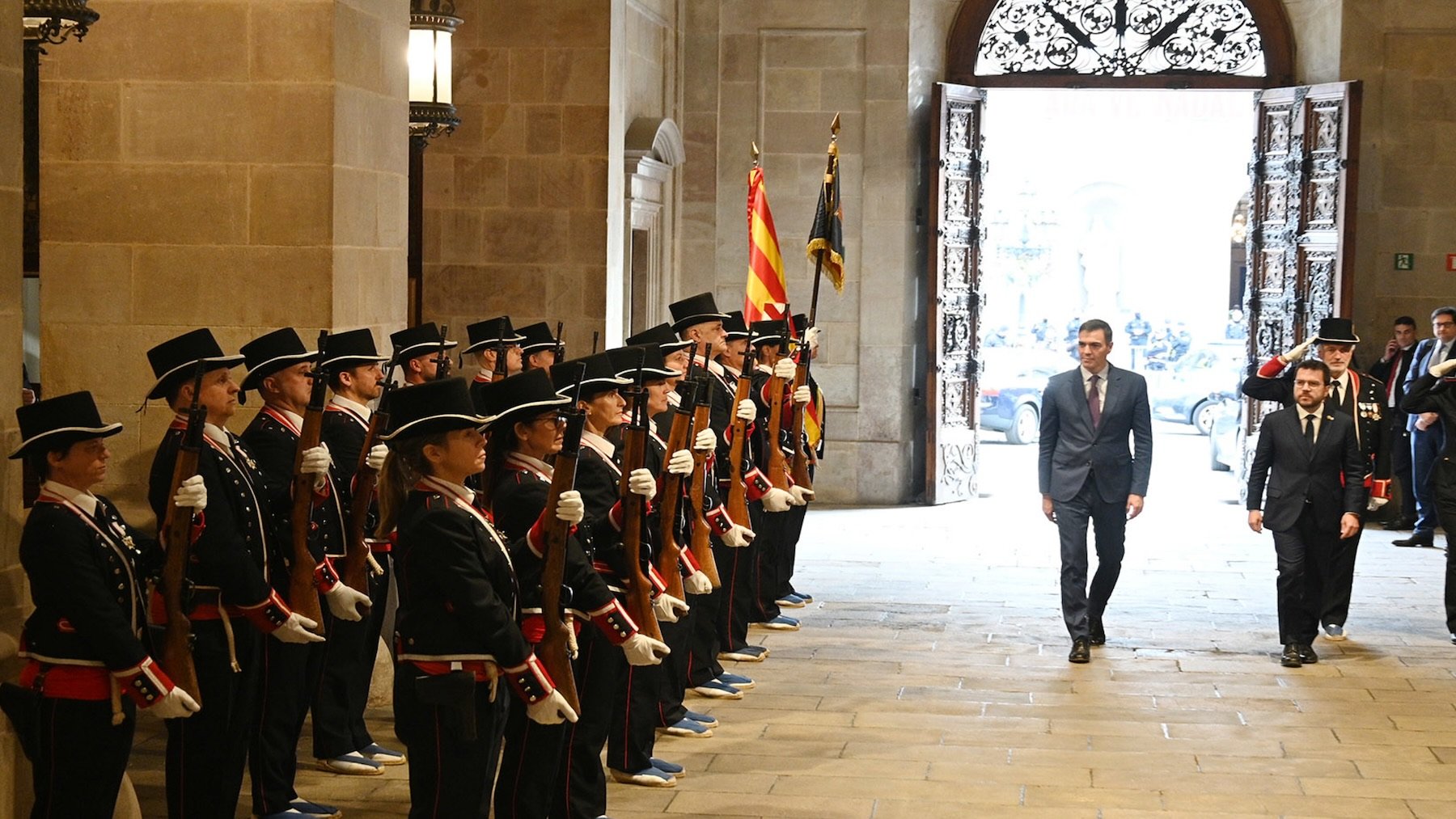 Pedro Sánchez y Pere Aragonés ante una formación de mossos vestidos con uniforme de gala.