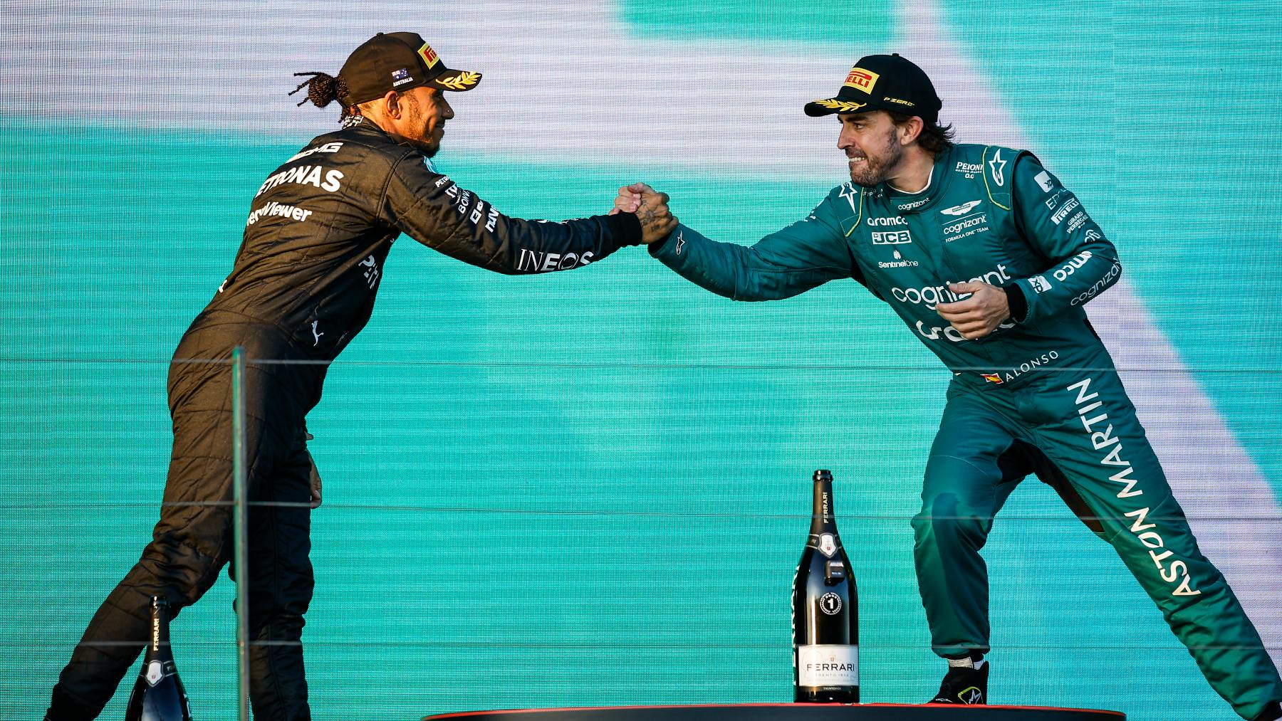 Fernando Alonso y Lewis Hamilton se dan la mano en un podio. (Europa Press)
