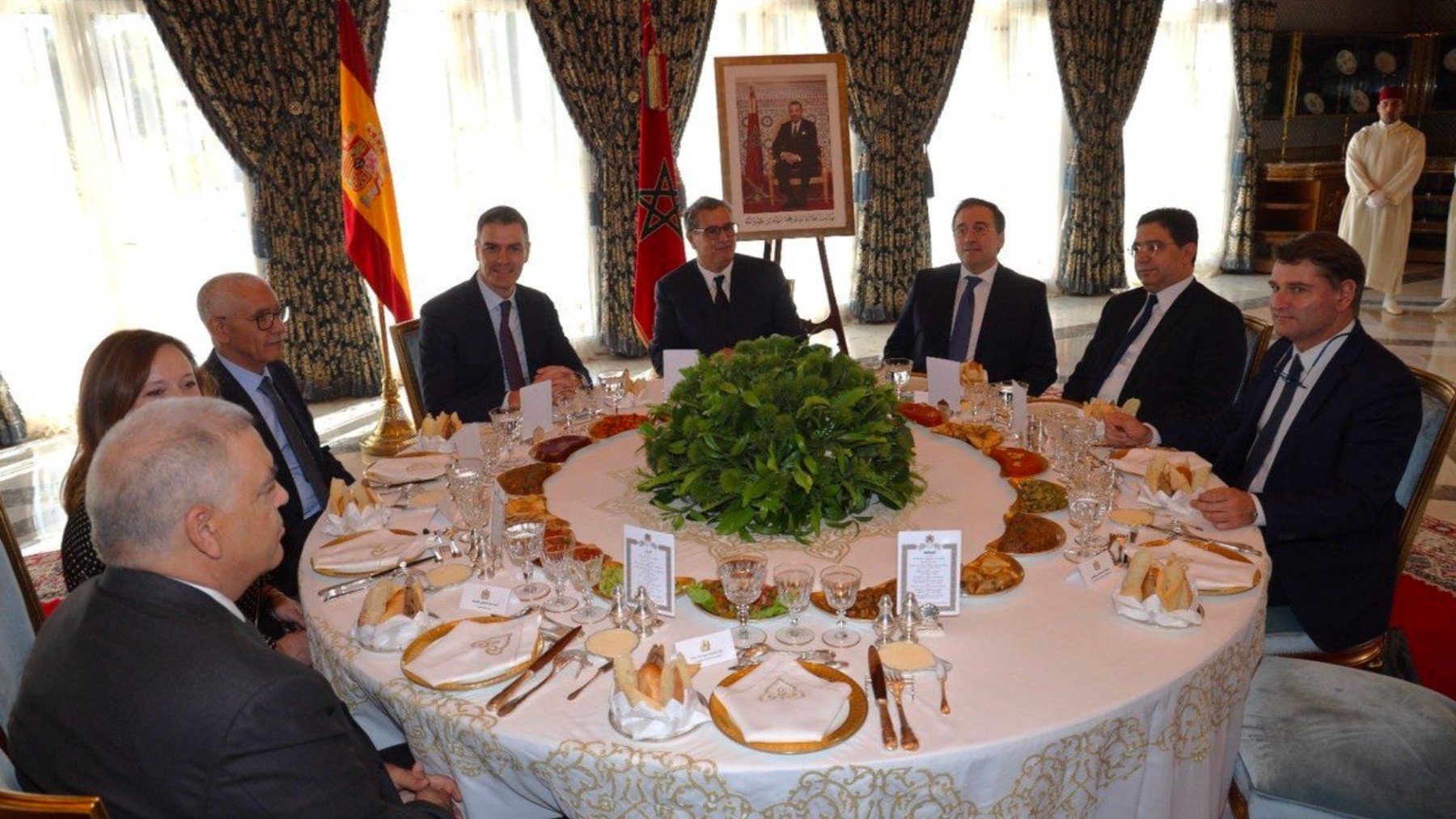 Sánchez en el almuerzo con la foto del rey Mohamed VI detrás.