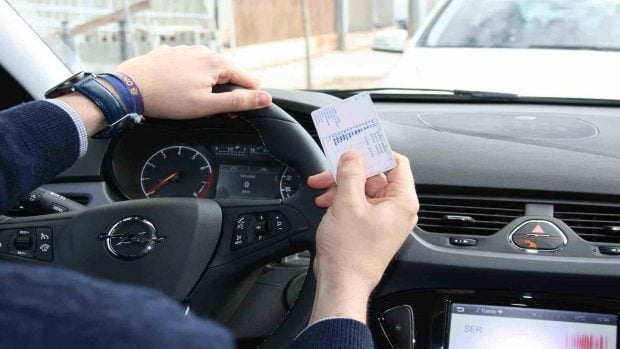 Conductor mostrando su carnet de conducir