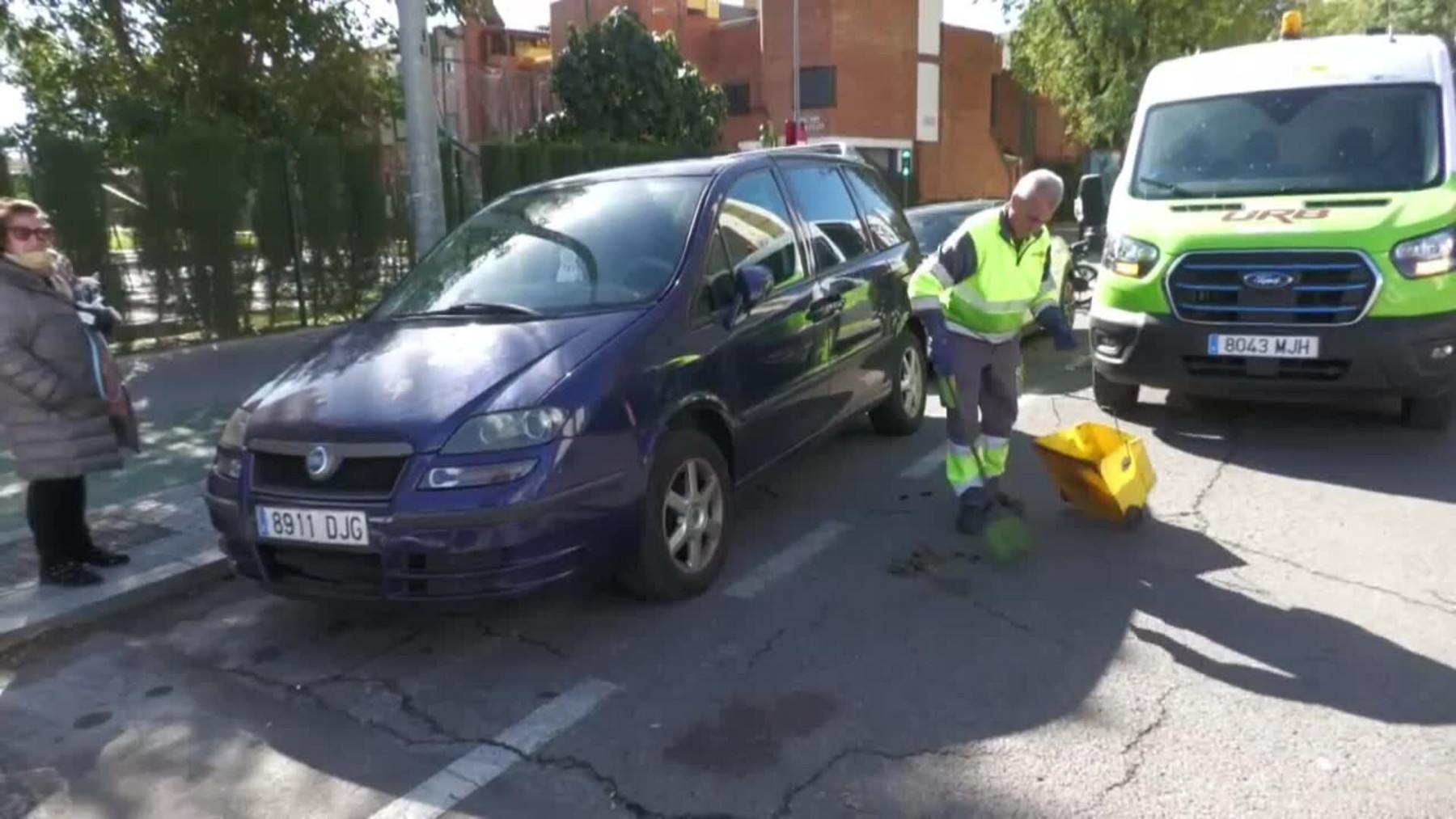 Un operario limpia los restos de sangre tras el asesinato este domingo de un joven en Sevilla.