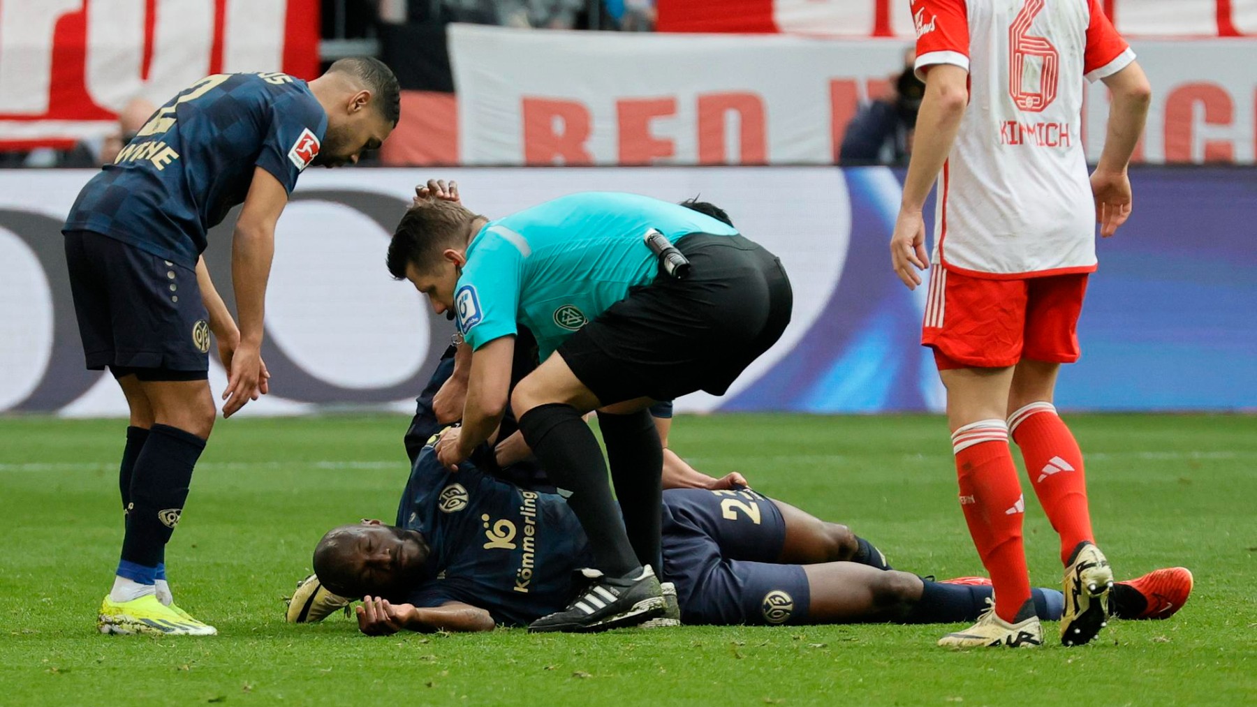 El momento en el que el árbitro atendió al jugador en el partido de la Bundesliga. (EFE)