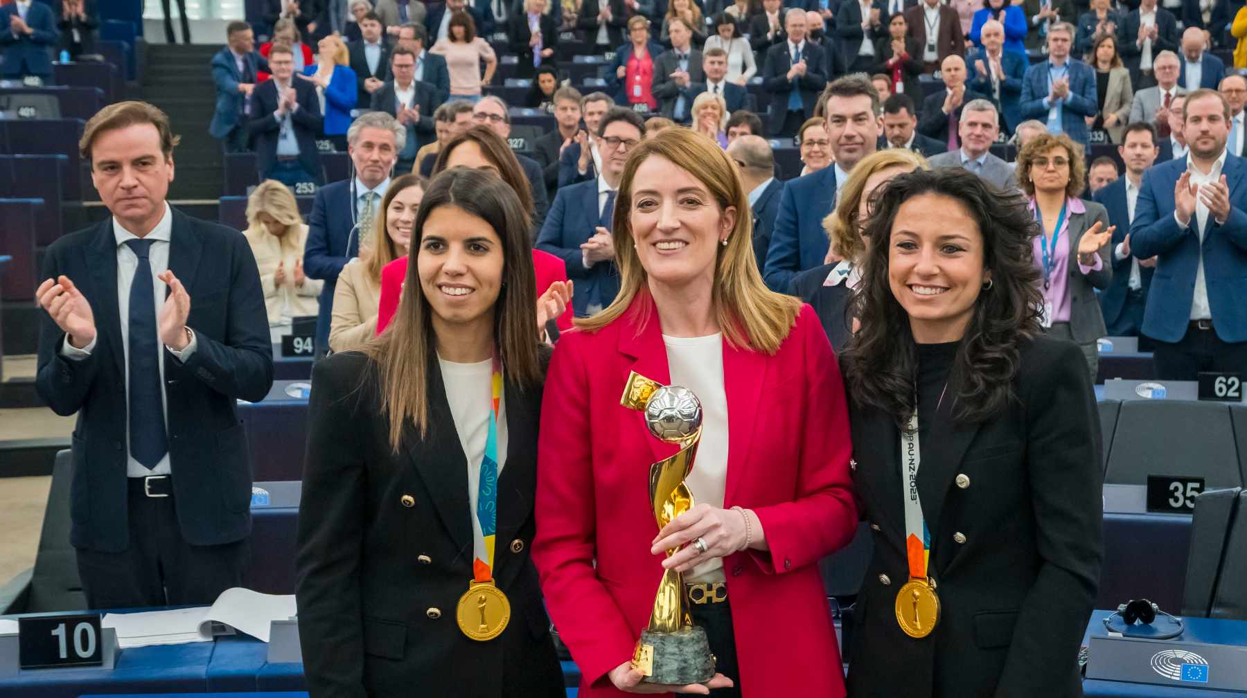 Ivana Andrés y Alba Redondo levantan el trofeo de campeonas del mundo en el Parlamento Europeo.