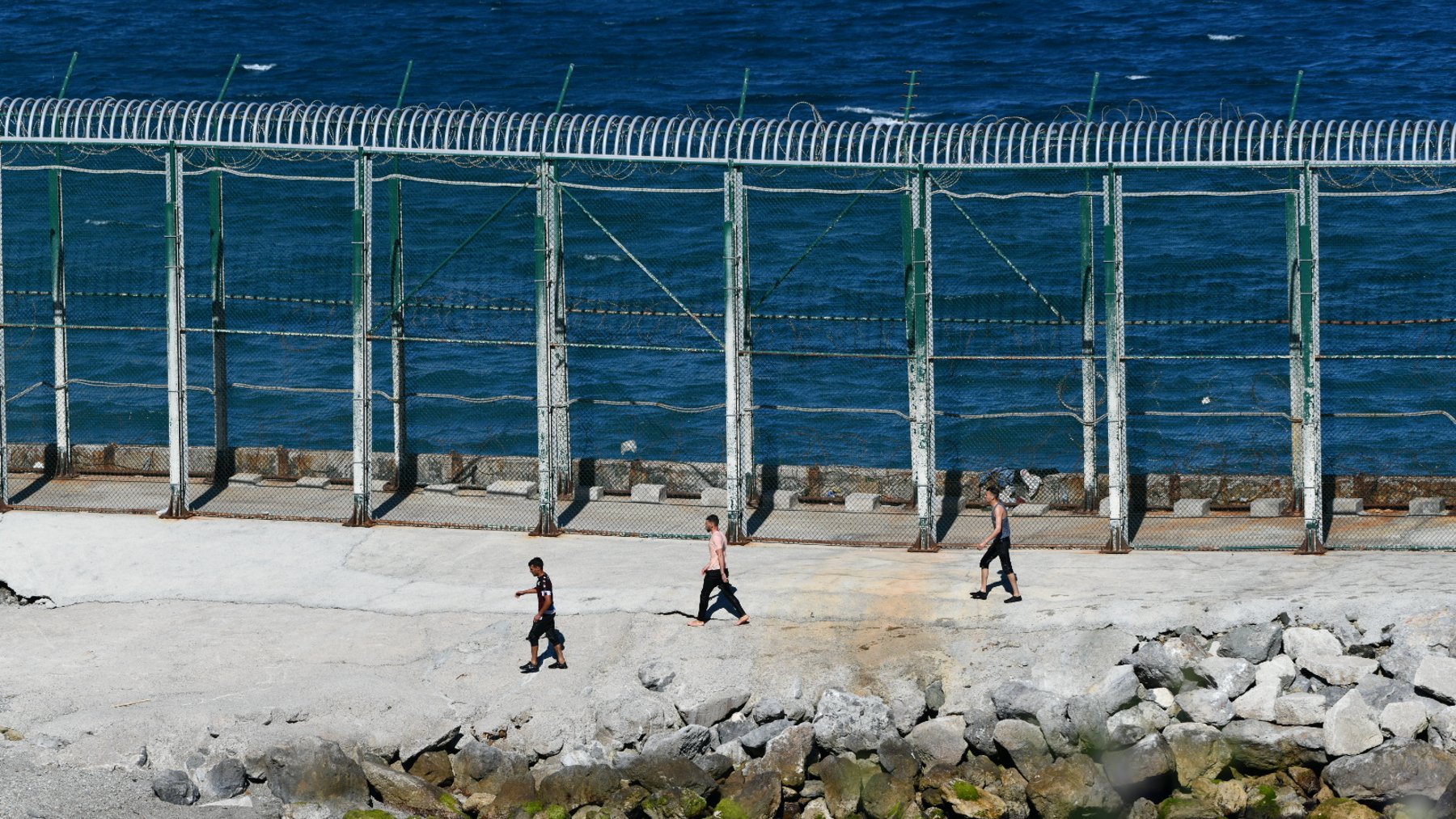 Varios jóvenes inmigrantes marroquíes en las inmediaciones de la valla de Ceuta, en la playa del Benzú (EP).