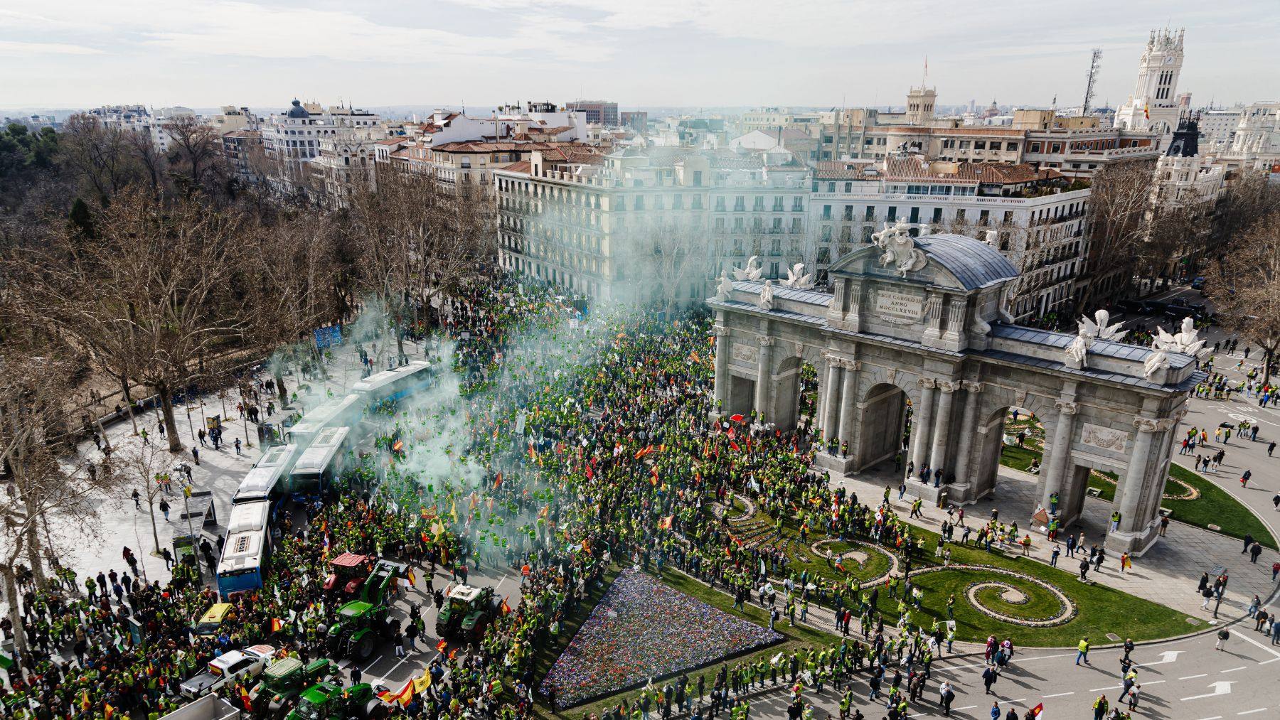 Cientos de agricultores reciben a las columnas de tractores en la Puerta de Alcalá. (Foto: Ep).