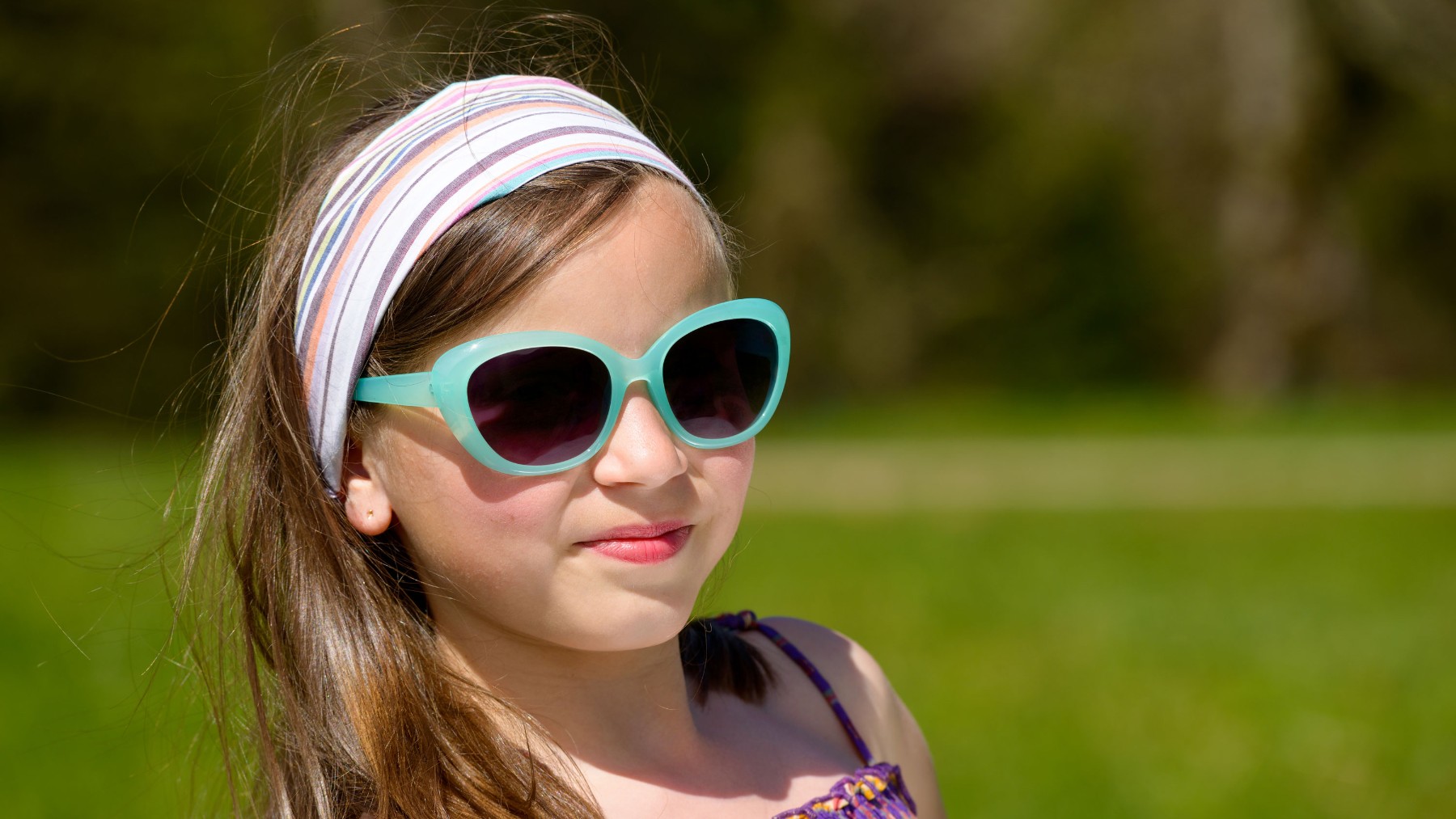 Una niña se protege de la radiación solar con gafas.
